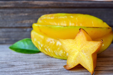 Fresh ripe carambola exotic fruit on old wooden table.Starfruit or averrhoa carambola background. Healthy food,vegetarian or diet concept.Selective focus.