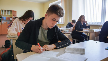 Schoolchild in class busy with work. Russian school.