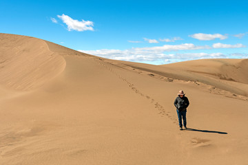 Fototapeta na wymiar Hiking Down a Lonely Sand Dune