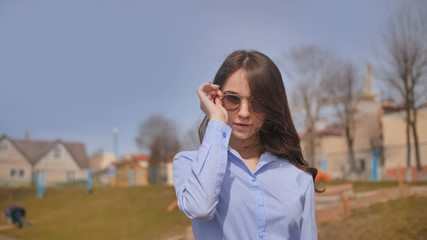 Beautiful 17 year old girl posing outdoors against the blue sky.