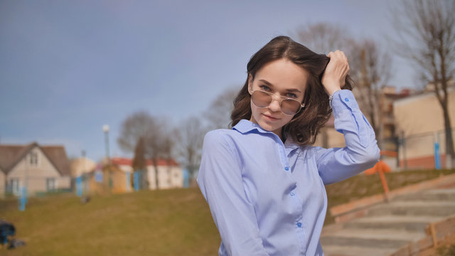 Beautiful 17 year old girl posing outdoors against the blue sky.