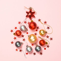 Christmas flat lay background on pink with holiday decorations.