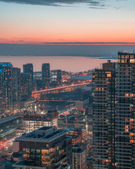 Obraz premium orange sunset glow over lake and city