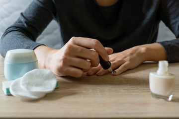 Woman doing the manicure. Removing the polish and putting on the cream. Woman that care his hands. Style concept.