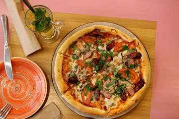 pizza with mushrooms, ham, vegetables and herbs on the table. view from the top