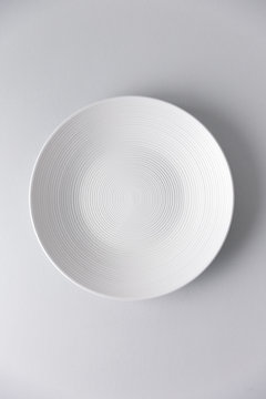 Textured white plate on pale background overhead