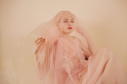Dreamy portrait of charming woman playing with veil