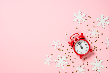 Christmas flat lay background with red clock and decor on pink.