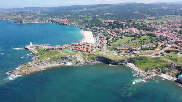 Aerial panoramic view of summer landscape overlooking small Spanish town of Comillas on coast of Cantabrian Sea