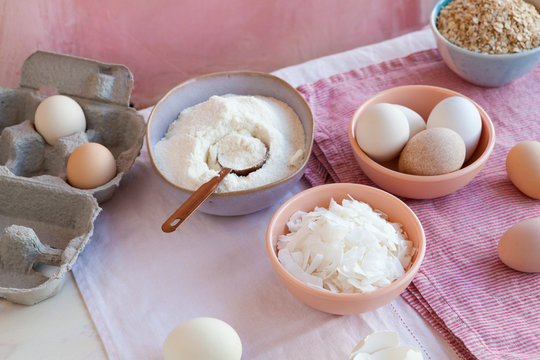Baking ingredients coconut flakes, coconut flour and eggs