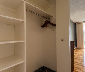 Empty closet with shelves, hangars, and glimpse of the bedroom beyond