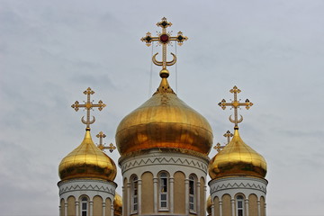 Fototapeta na wymiar Crosses on Church Golden Domes on gray sky background, Christisnity symbol