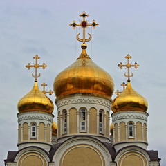 Fototapeta na wymiar Beautiful Russian Spiridon Church domes with Crosses on gray sky background on Kolomenskaya, Nagatinsky Zaton, Moscow