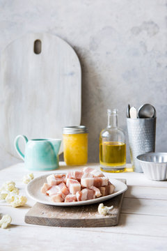Kitchen countertop with cooking ingredients including diced bacon, oil and clarified butter