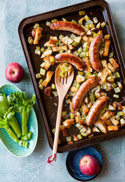Top view of sausage with baked apple, celery and crispy bread