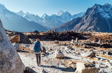 Papier peint adhésif Ama Dablam Young female backpacker following Everest Base Camp trekking route using trekking poles and enjoying valley view with Ama Dablam peak. She came to Everest Memorial to lost Mountaineers (4800m)