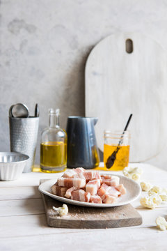Kitchen countertop with cooking ingredients including diced bacon, oil and clarified butter