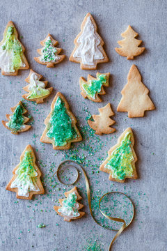 Christmas tree cookies decorated with green edible glitter and festive sprinkles