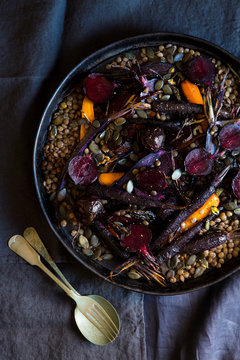 Roasted vegetables with brown lentils. Purple carrot, orange carrots and beetroot and pumpkin seeds
