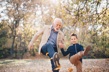 Grand-leg work. A grandson learning from his grandfather how to properly kick a football/soccerball, in the park.