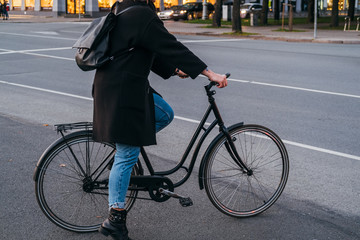 Naklejka premium Women on city bicycle in traffic on the city roadway