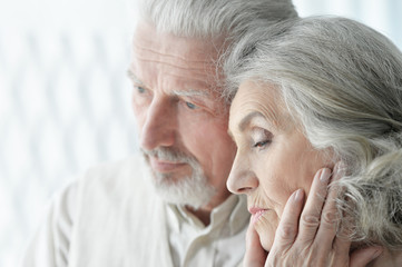 Portrait of sad senior couple posing at home