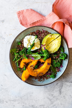 Poached egg and quinoa bowl with squash, broccolini and avocado salad