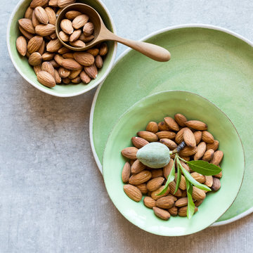 Top view of whole almond nuts in bowls