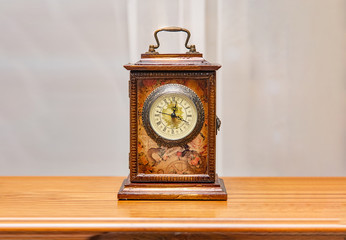 Square wooden vintage clock on a shelf