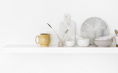 An arrangement of modern and vintage tableware on kitchen wall shelf