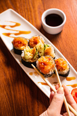 woman eating sushi with soy sauce