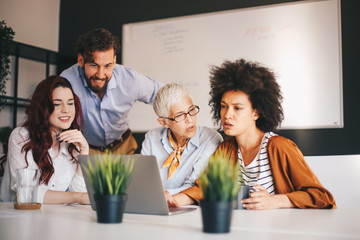 Four business-people brainstorming about project in the modern office.
