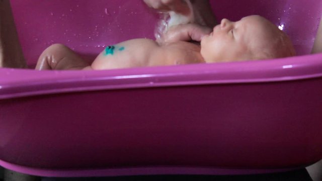 bathing a newborn baby,newborn baby girl bathe in the bathroom