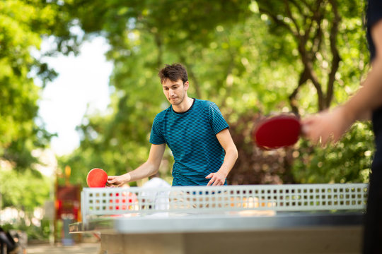 young man playing table tennis in park
