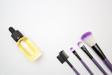 Cosmetics and skin care concept. Glass dropper bottle and makeup brush set