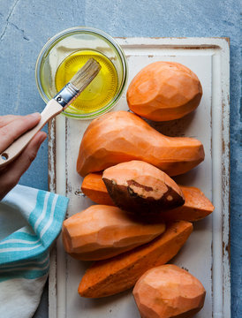 Basting Sweet Potatoes With Olive Oil As Seen From Above