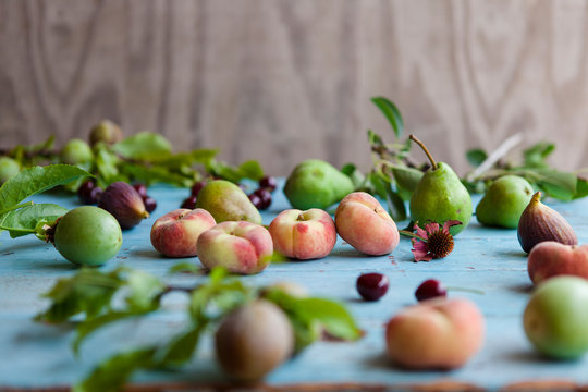 Summer fruits, donut peaches, green pears, cherries, figs and passion fruit