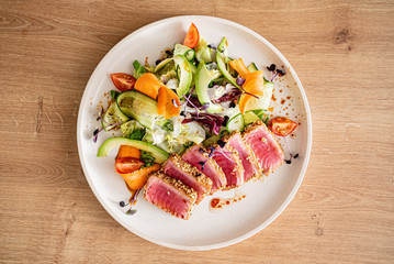 tuna steak with fresh salad on teh wooden background
