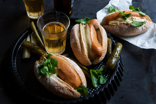 Hotdogs with mustard, pickle and a glass of beer
