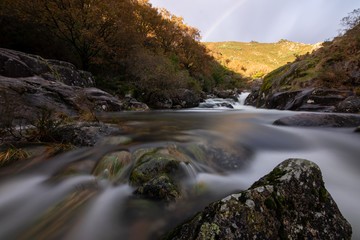 Landscape of a rocky river with cloudy sky, silk effect, long exposure  in Puente Caldelas, A Lama, Pontevedra, Spain.