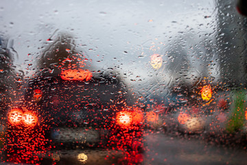 wet windshield water flows blurred car lights
