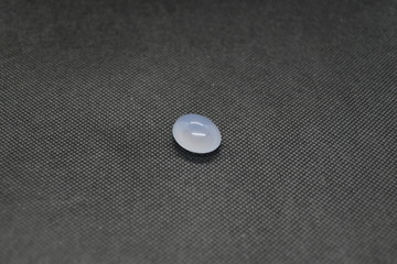 Natural Chalcedony in a shape of cobochon on black fabric background.