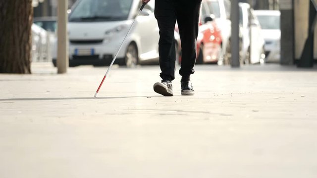 close up on blind man with stick walking in the city.Blindness, autonomy