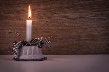 Geburtstagskerze vor Holzhintergrund