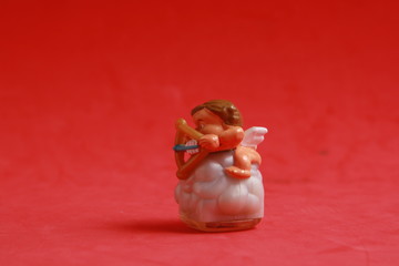 plastic cupid shaped toy in color background