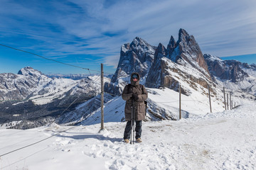 Fototapeta na wymiar Woman on top of Seceda in Italian Dolomites in winter time on snow