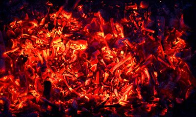 Fototapeta na wymiar abstraction yellow-red coals smolder against the background of the night, the remains of firewood