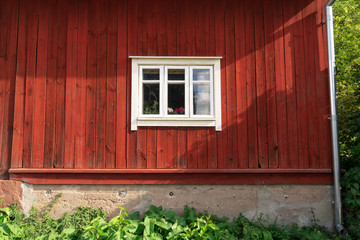 Close up of a white window in old red wooden traditional Finnish house, Turku, Finland.