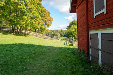 View of an old wooden barn in Turku, Finland. Fall is just starting to show it's colours.