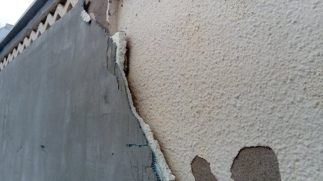 Crack on the wall of the house. Old plaster falls off the surface. Defect during construction. The effect of humidity on the structure. Violation of the technology of the construction process